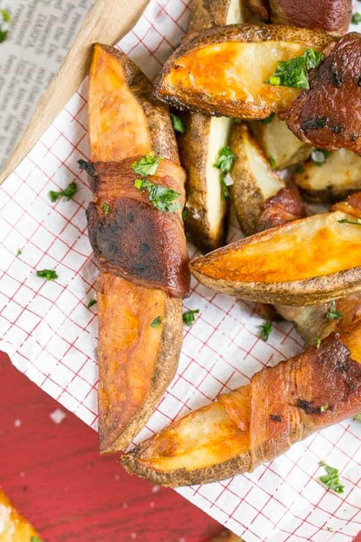 Bacon Wrapped Potato Wedges Recipe | Best Potato Wedges | Bacon Wrapped French Fries | Bacon Potato Wedges #bacon #potato #fries #dinner #ezlod Bacon wrapped potatoes on a serving tray, topped with parsley.