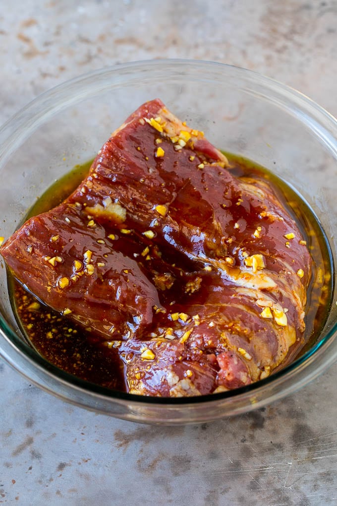 Flank Steak Marinade Recipe | Marinated Flank Steak | Marinated Steak | Steak Marinade #steak #beef #grilling #marinade #dinner #ezlod Raw flank steak in a bowl of marinade.