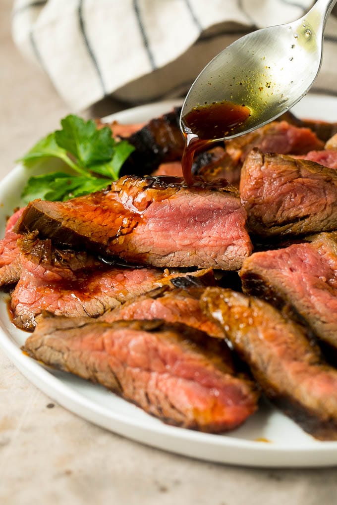 Flank Steak Marinade Recipe | Marinated Flank Steak | Marinated Steak | Steak Marinade #steak #beef #grilling #marinade #dinner #ezlod Flank steak marinade being drizzled over meat.