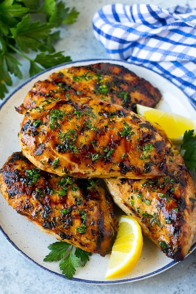 Grilled Chicken Breast Recipe | Marinated Chicken Breast | Chicken Marinade #chicken #grilling #marinade #summer #dinner #ezlod A platter of grilled chicken breast served with parsley and lemon.