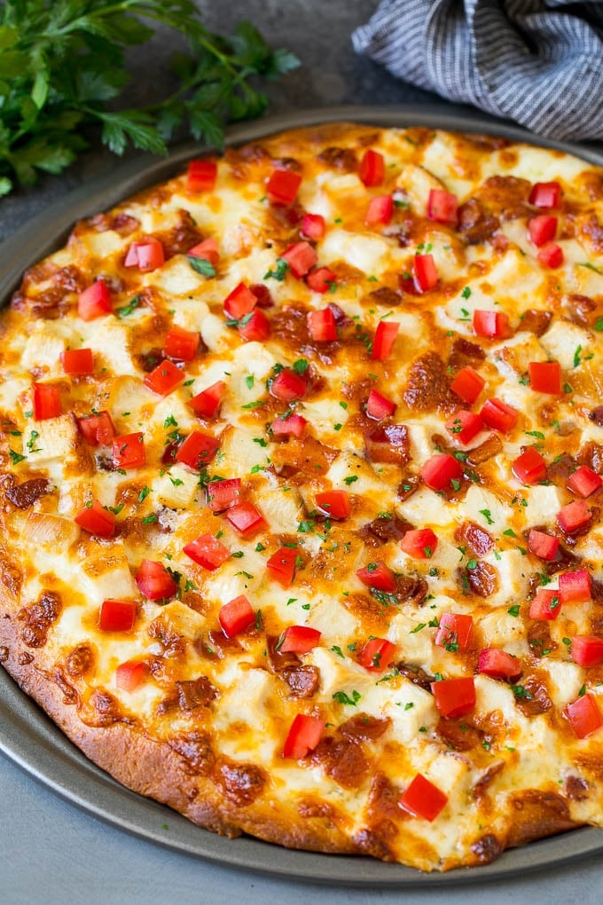 Chicken Alfredo Pizza Recipe #pizza #chicken #bacon #dinner #ezlod A pizza topped with chicken, bacon, tomatoes and parsley.
