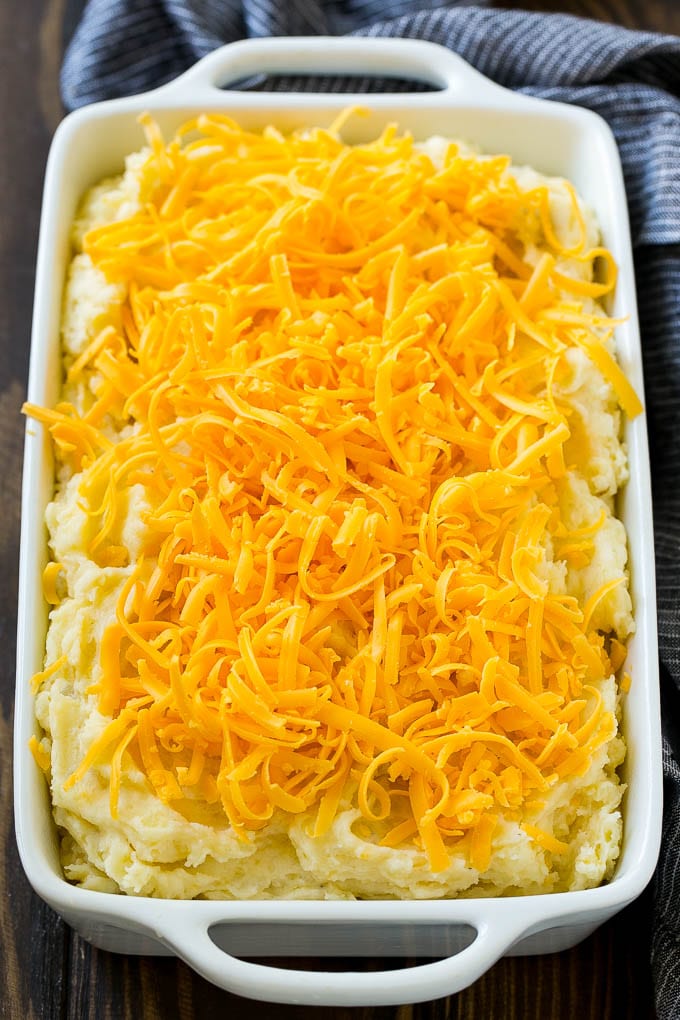Loaded Mashed Potato Casserole Recipe | Loaded Potatoes | Bacon Mashed Potatoes | Thanksgiving Mashed Potatoes #potatoes #bacon #cheese #casserole #Thanksgiving #dinner #ezlod Mashed potatoes in a casserole dish, topped with shredded cheese.