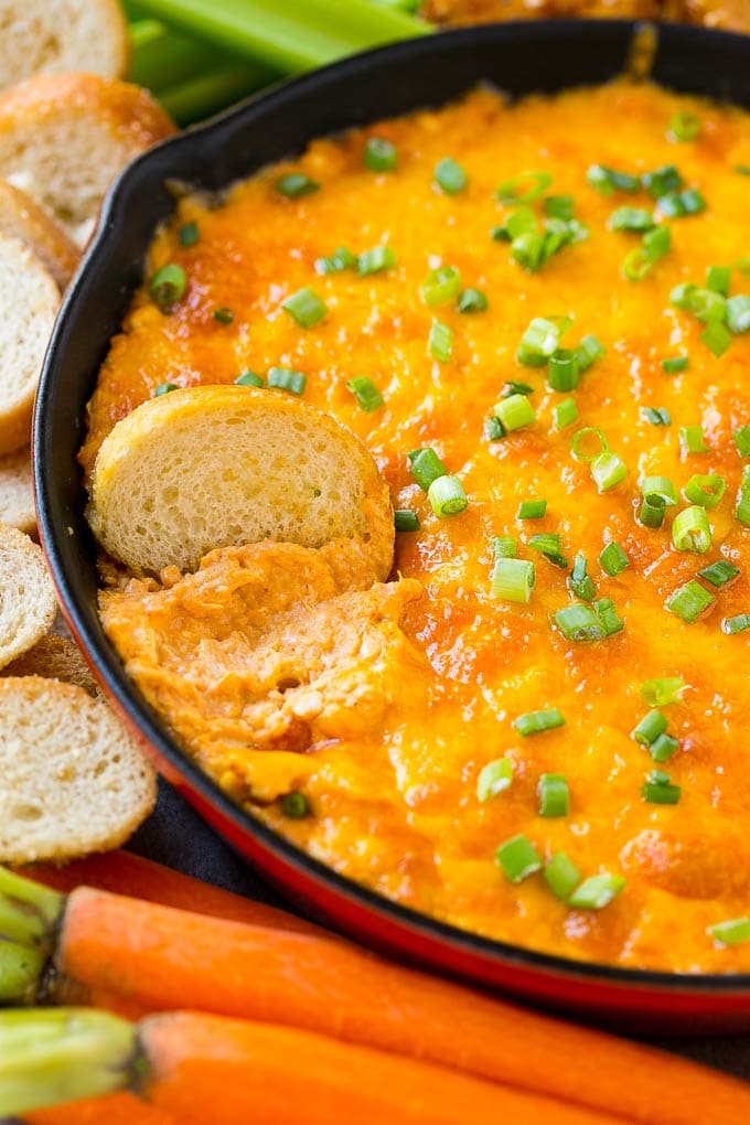Buffalo Ranch Chicken Dip | Buffalo Chicken Dip | Baked Buffalo Dip | Cheesy Buffalo Dip #buffalowings #buffalochicken #dip #lowcarb #appetizer #ezlod Buffalo ranch chicken dip with a baguette slice in it.