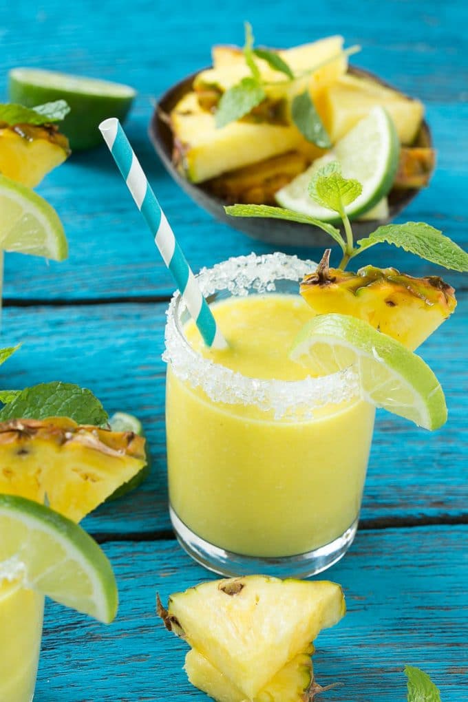 Pineapple Coconut Smoothie Recipe |Tropical Smoothie | Pineapple Smoothie #smoothie #pineapple #coconut #healthy #cleaneating #ezlod A tropical smoothie with a paper straw in it.
