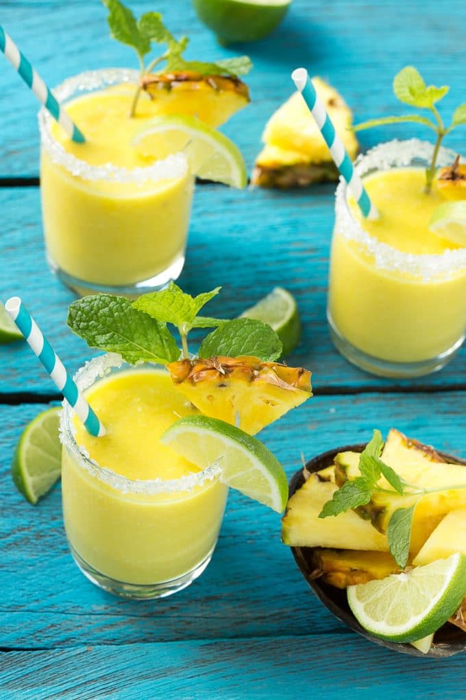 Pineapple Coconut Smoothie Recipe |Tropical Smoothie | Pineapple Smoothie #smoothie #pineapple #coconut #healthy #cleaneating #ezlod Pineapple coconut smoothies in glasses with sugared rims.