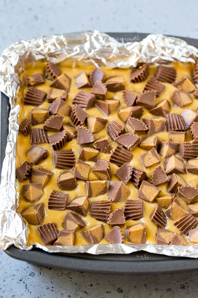 Chocolate Peanut Butter Fudge Recipe | Peanut Butter Cup Fudge | Easy Fudge Recipe #chocolate #peanutbutter #fudge #baking #dessert #ezlod Layered peanut butter chocolate fudge in a square pan.