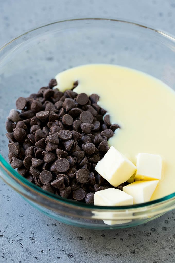 Chocolate Peanut Butter Fudge Recipe | Peanut Butter Cup Fudge | Easy Fudge Recipe #chocolate #peanutbutter #fudge #baking #dessert #ezlod Chocolate chips, condensed milk and butter in a mixing bowl.