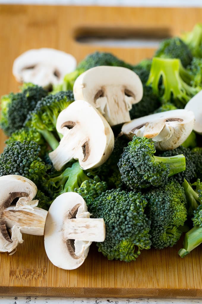 Chicken and Broccoli Stir Fry Recipe | Chicken Stir Fry | Healthy Chicken Recipe | Chicken and Broccoli | Chinese Food #chicken #broccoli #stirfry #healthy #cleaneating #dinner #ezlod Broccoli florets and sliced mushrooms on a cutting board.