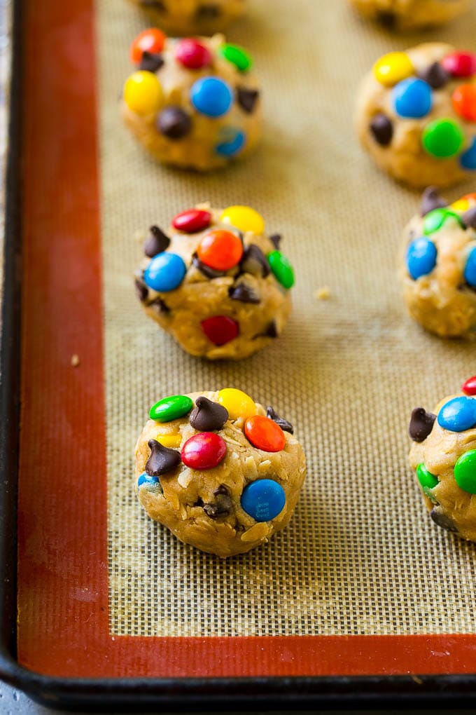 Monster Cookies Recipe | Oatmeal Cookies | Peanut Butter Cookies | M&M's Cookies #baking #cookies #dessert #peanutbutter #chocolate #ezlod Balls of cookie dough on a baking sheet.