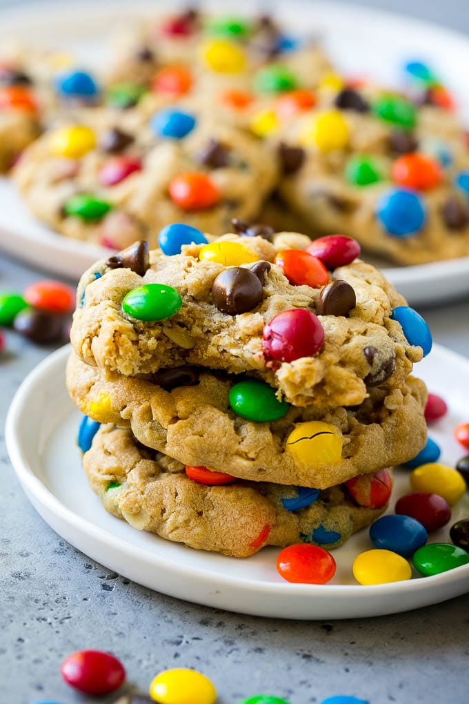 Monster Cookies Recipe | Oatmeal Cookies | Peanut Butter Cookies | M&M's Cookies #baking #cookies #dessert #peanutbutter #chocolate #ezlod A stack of monster cookies with a bite taken out of one.
