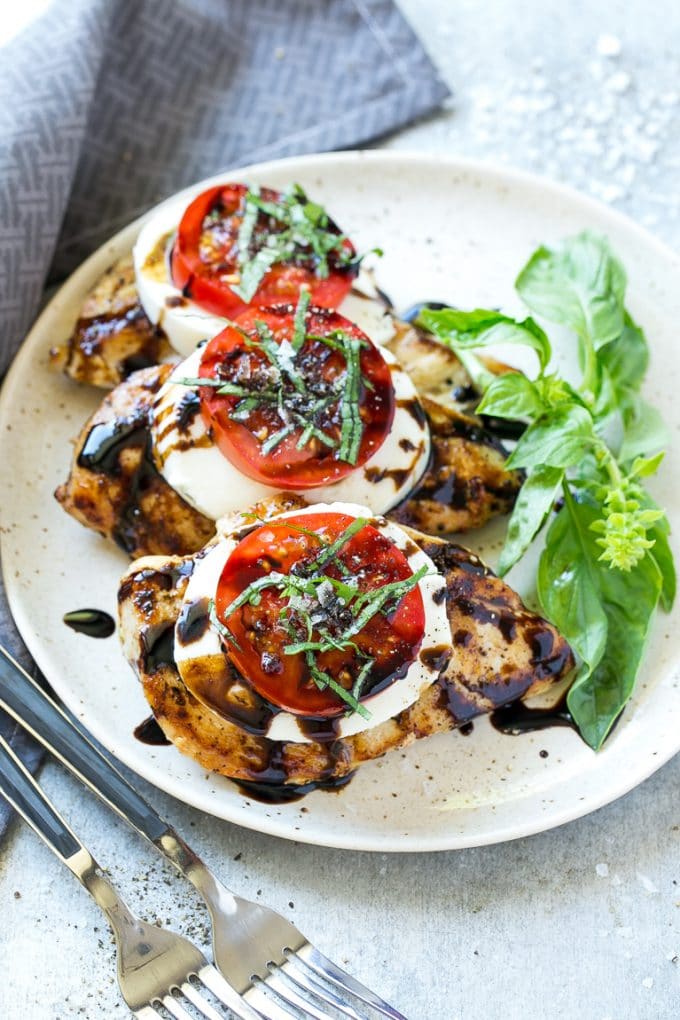 Chicken Caprese Recipe | Grilled Chicken #chicken #caprese #grilling #dinner #tomato #basil #ezlod A plate of caprese chicken breasts topped with fresh mozzarella cheese, tomatoes and basil.