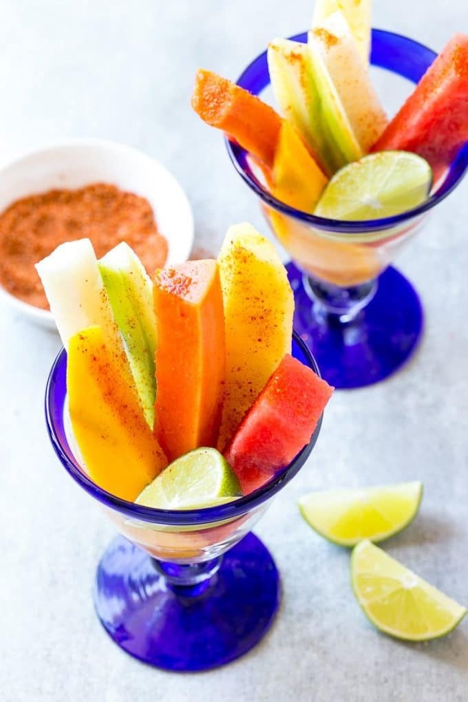 Mexican Fruit Cups | Fruit Cups | Mexican Fruit | Tropical Fruit #fruit #fruitcup #watermelon #pineapple #snack #healthy #ezlod Spears of watermelon, cucumber, jicama, mango and pineapple in glasses.