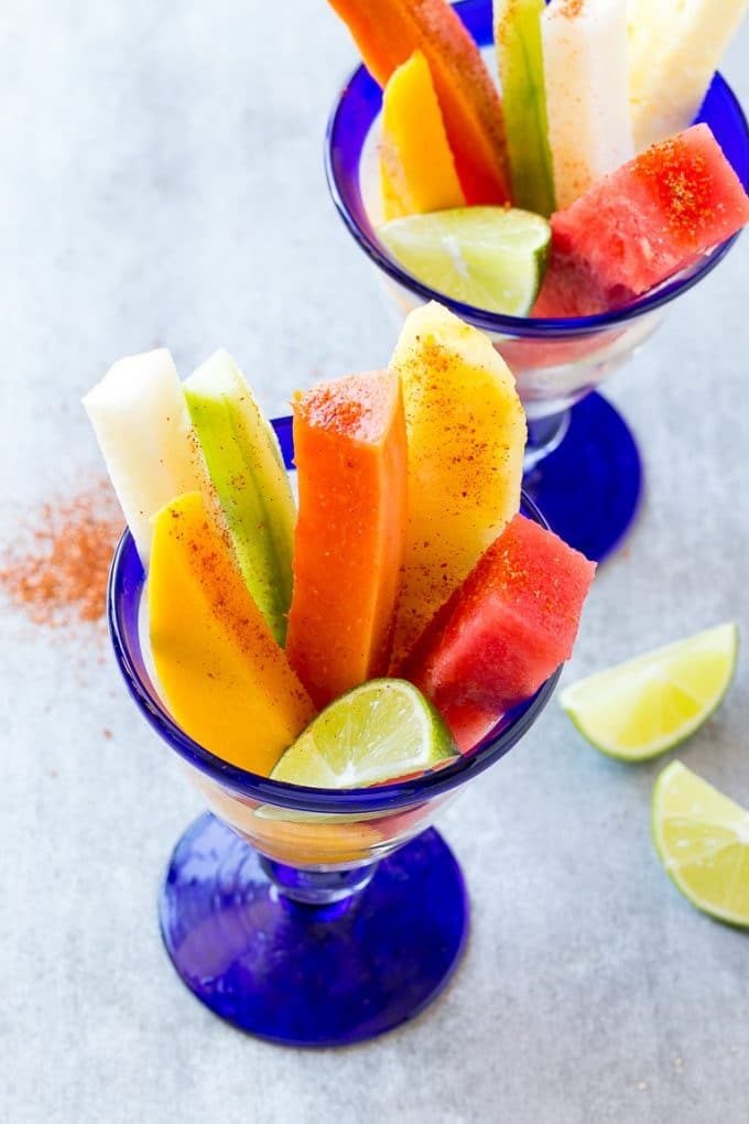 Mexican Fruit Cups | Fruit Cups | Mexican Fruit | Tropical Fruit #fruit #fruitcup #watermelon #pineapple #snack #healthy #ezlod Mexican fruit cups with an assortment of fruit, topped with chili lime seasoning.
