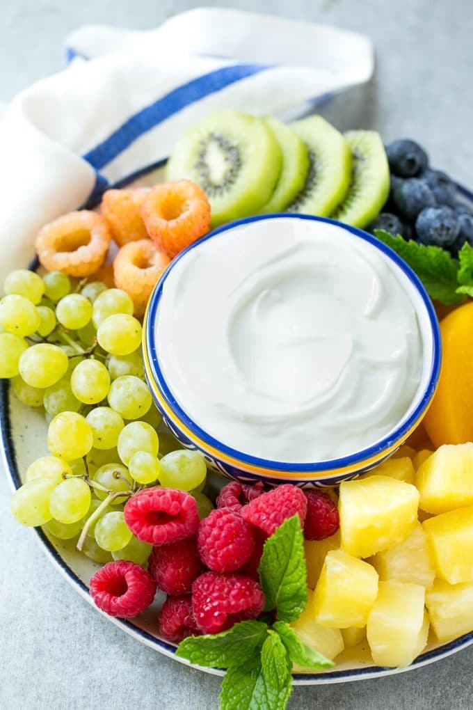 Cream Cheese Fruit Dip | Fruit Recipe | Fruit Dip #fruit #dip #creamcheese #snack #dessert #ezlod A bowl of cream cheese fruit dip surrounded by colorful fruit.