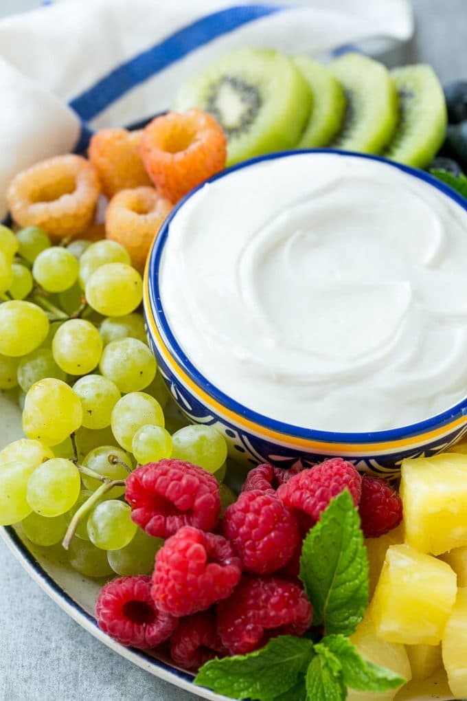 Cream Cheese Fruit Dip | Fruit Recipe | Fruit Dip #fruit #dip #creamcheese #snack #dessert #ezlod A bowl of cream cheese fruit dip surrounded by grapes, raspberries and kiwis.