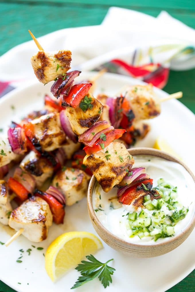 Greek Chicken Kabobs | Grilled Chicken Kabobs | Healthy Chicken Recipe | Greek Chicken #greekfood #chicken #grilling #grilledchicken #kabobs #dinner #ezlod Skewered meat and veggies being dipped onto cucumber yogurt sauce.
