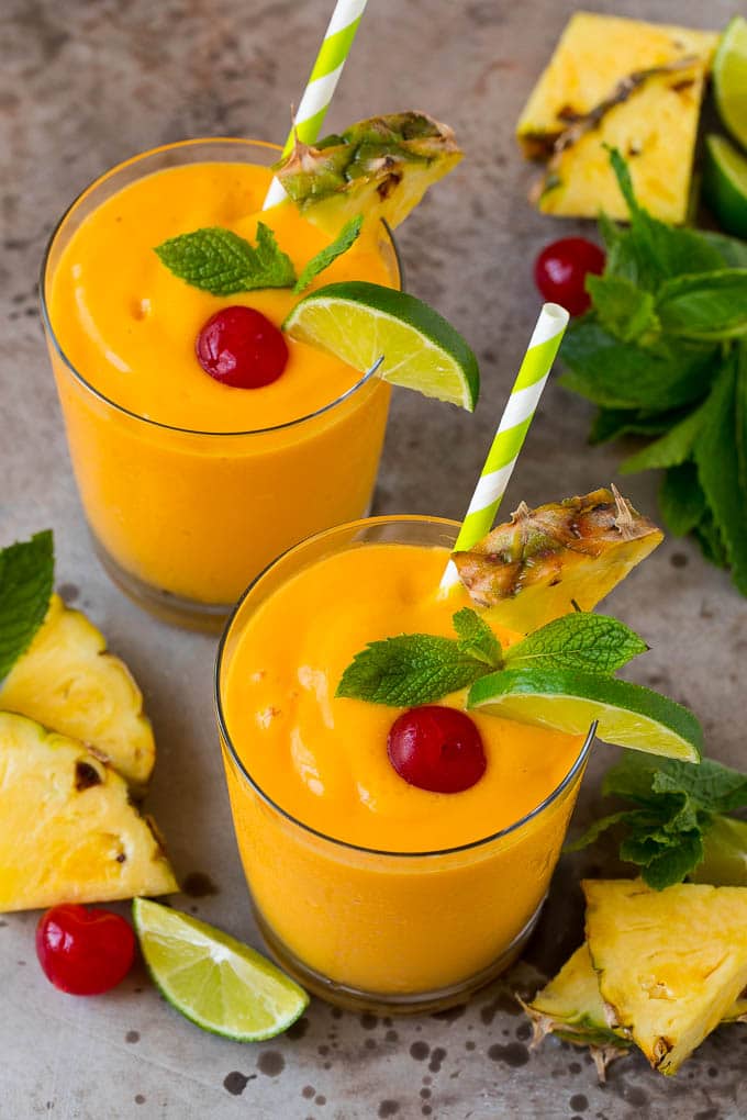 Tropical Smoothie Recipe | Mango Smoothie | Pineapple Smoothie #smoothie #mango #pineapple #banana #drink #ezlod Tropical smoothie garnished with mint, limes and pineapple.
