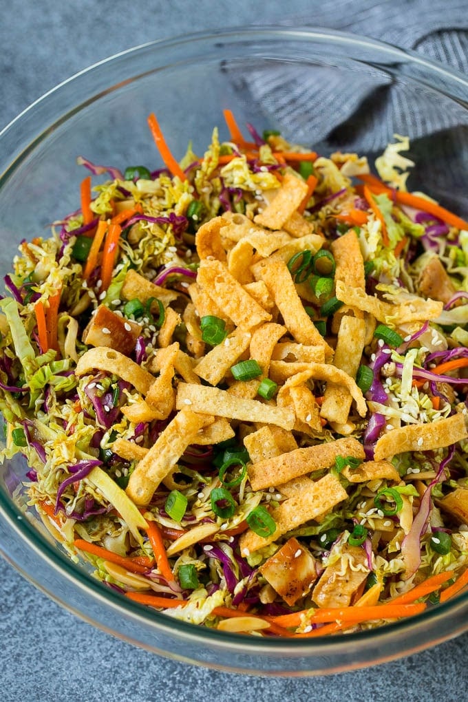 Chinese Chicken Salad Recipe | Asian Chicken Salad #salad #chicken #chickensalad #cabbage #lunch #dinner #ezlod A bowl of Chinese chicken salad topped with wontons and sesame seeds.