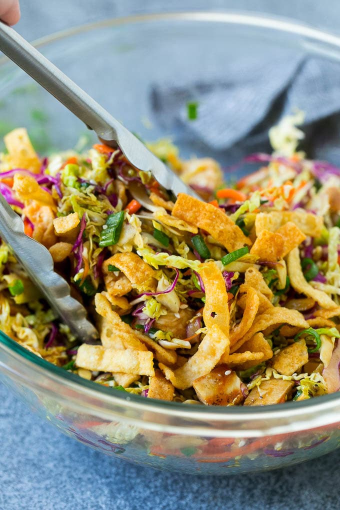 Chinese Chicken Salad Recipe | Asian Chicken Salad #salad #chicken #chickensalad #cabbage #lunch #dinner #ezlod Tongs serving up a portion of Asian chicken salad.