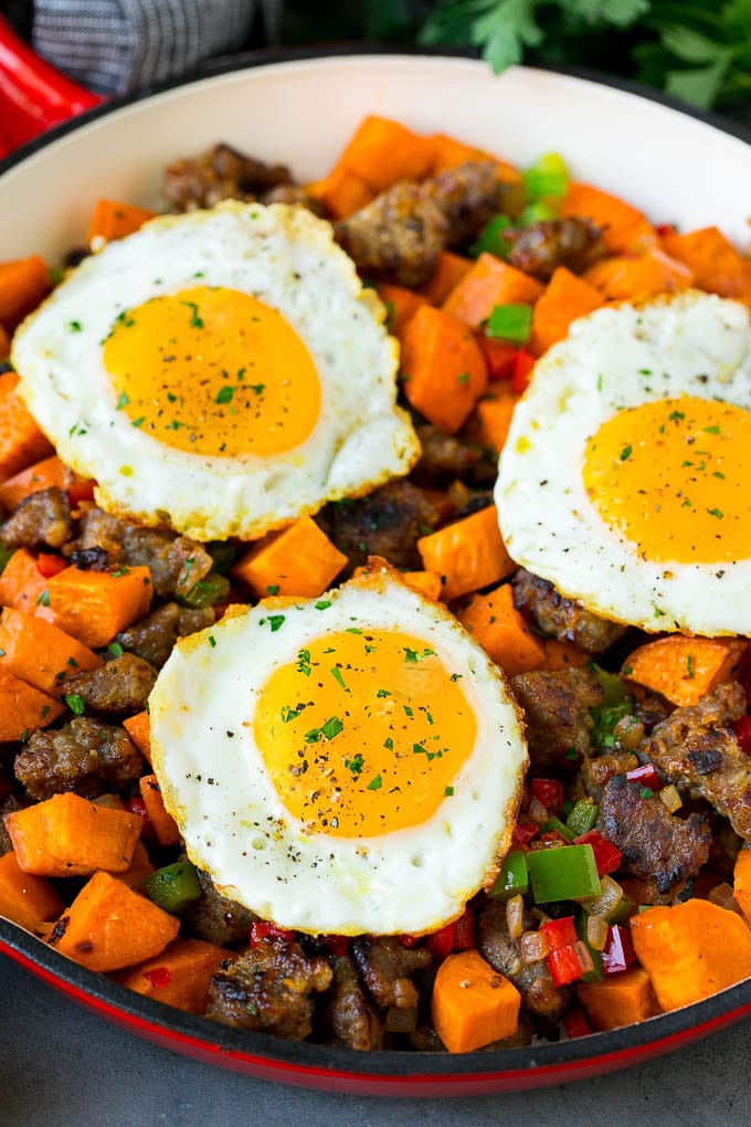 Sweet Potato Hash #sweetpotato #sausage #breakfast #brunch #ezlod A pan of sweet potato hash topped with fried eggs.