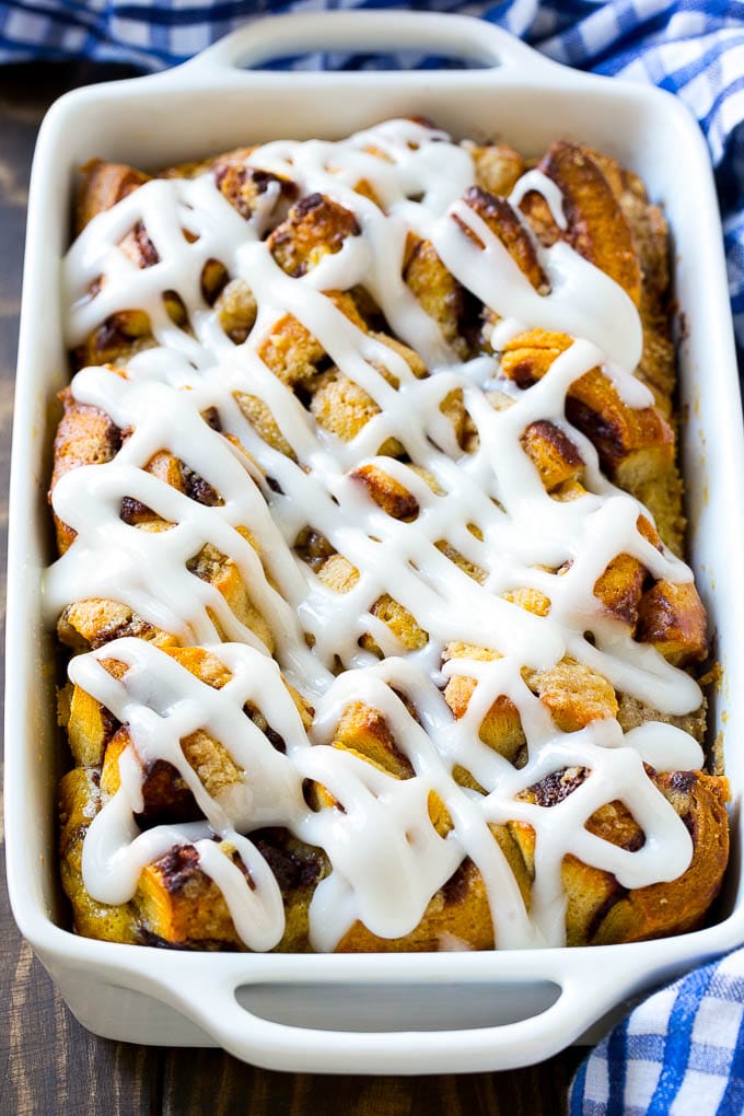 Cinnamon Roll French Toast Casserole | Cinnamon Roll French Toast Bake | Cinnamon Roll French Toast | Cinnamon French Toast #casserole #frenchtoast #cinnamonrolls #breakfast #ezlod A casserole dish of cinnamon roll french toast with icing poured over the top.