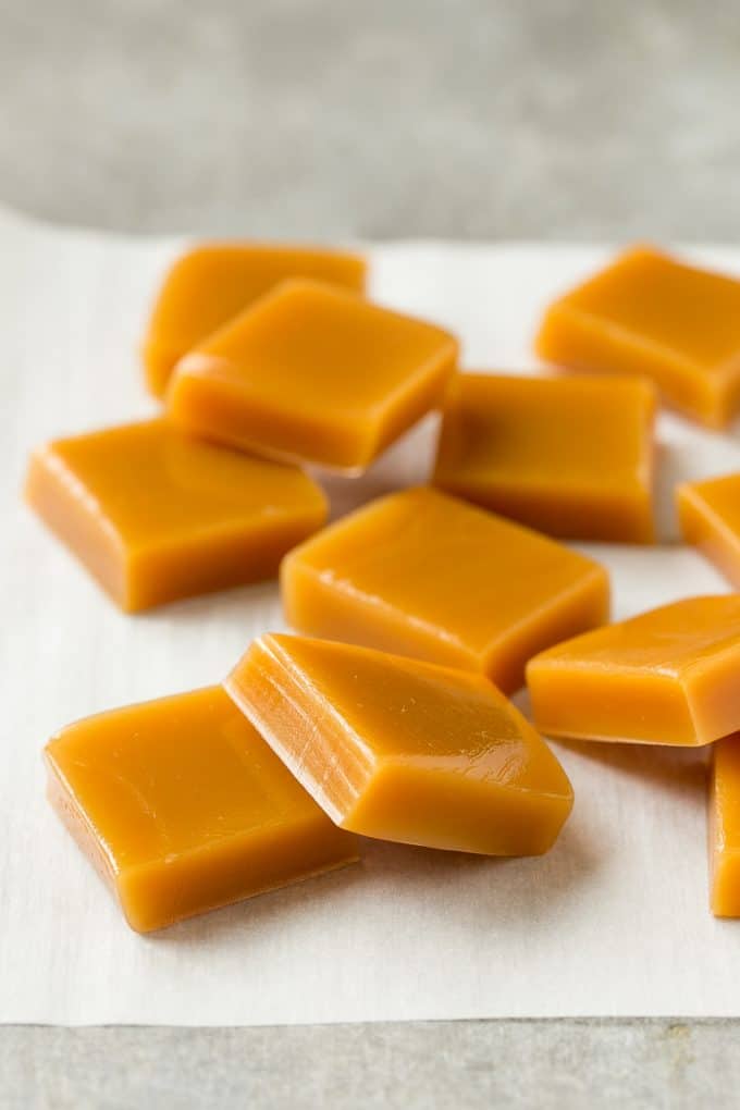 Microwave Caramels with Sea Salt Recipe | Homemade Caramels | Sea Salt Caramel | Homemade Candy #candy #caramels #caramel #microwavecaramels #homemade #dessert #ezlod Squares of cooked caramel on parchment.