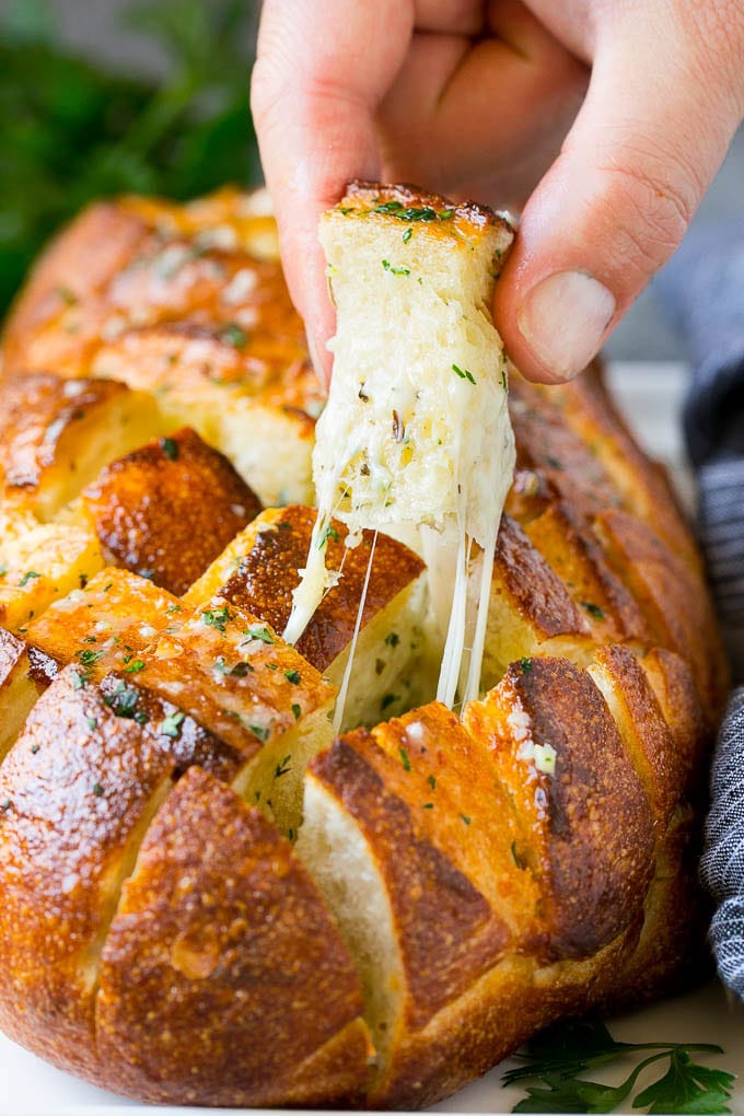 Pull Apart Bread | Garlic Bread | Cheese Bread #bread #garlic #cheese #sidedish #appetizer #ezlod A hand grabbing a piece of pull apart bread.
