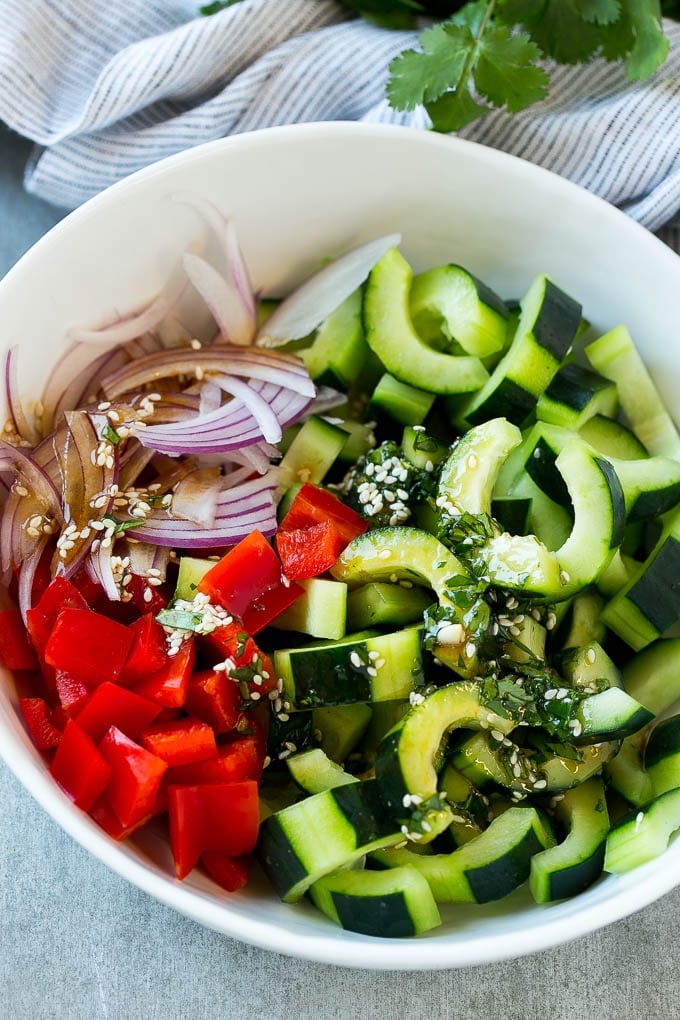 Asian Cucumber Salad Recipe | Sesame Cucumber Salad | Cucumber Salad | Healthy Salad | Healthy Cucumber Recipe #cucumber #cucumbersalad #salad #sidedish #ezlod Sliced cucumbers, red peppers and onions with dressing.