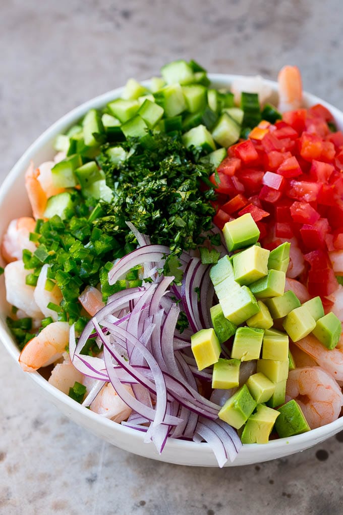 Shrimp Ceviche Recipe | Mexican Shrimp | Marinated Shrimp #shrimp #ceviche #cleaneating #healthy #lowcarb #keto #glutenfree #dinner #appetizer #ezlod Prawns, avocado, red onion tomatoes, cilantro, jalapeno and cilantro in a bowl.