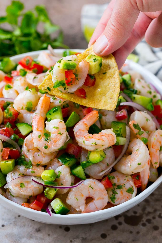 Shrimp Ceviche Recipe | Mexican Shrimp | Marinated Shrimp #shrimp #ceviche #cleaneating #healthy #lowcarb #keto #glutenfree #dinner #appetizer #ezlod A bowl of shrimp ceviche with a tortilla chip scooping some out.