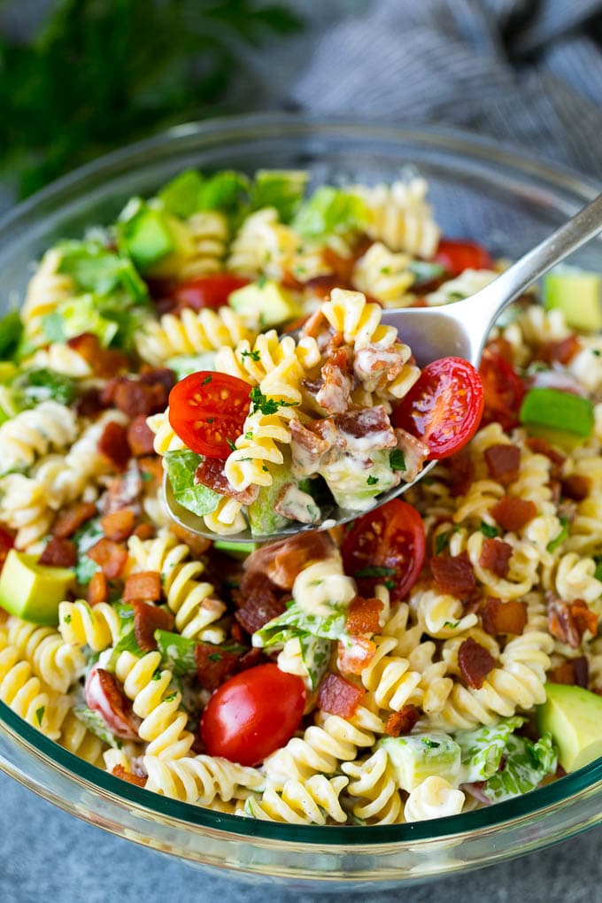 BLT Pasta Salad Recipe | Easy Pasta Salad | Bacon Pasta Salad #salad #pasta #blt #bacon #avocado #dinner #ezlod A serving spoon filled with BLT pasta salad.