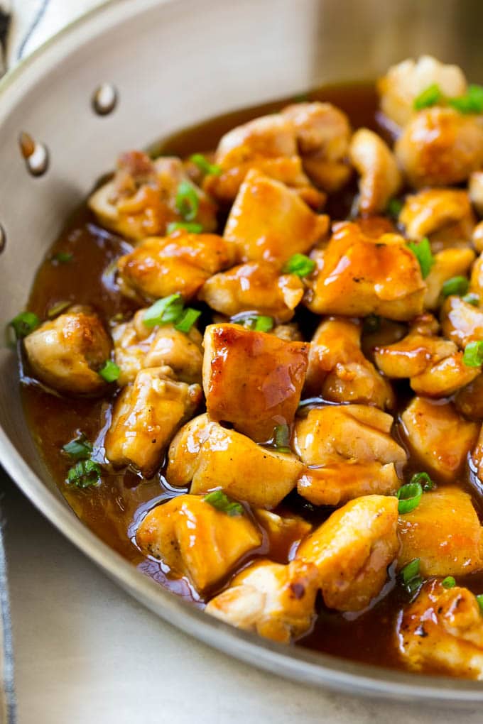 Bourbon Chicken | Sauteed Chicken | Chicken Stir Fry | Easy Chicken Recipe #chicken #dinner #ezlod Bourbon chicken in a skillet coated in sauce and topped with green onions.