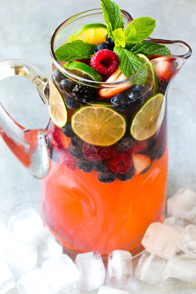 Berry Champagne Punch Recipe | Champagne Cocktail | Lime Cocktail | Berry Punch | Champagne Recipe #champagne #punch #berries #drink #ezlod A pitcher of a cocktail garnished with fruit and mint.