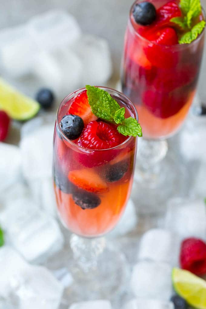 Berry Champagne Punch Recipe | Champagne Cocktail | Lime Cocktail | Berry Punch | Champagne Recipe #champagne #punch #berries #drink #ezlod Two glasses of refreshing champagne punch with berries and mint on top.