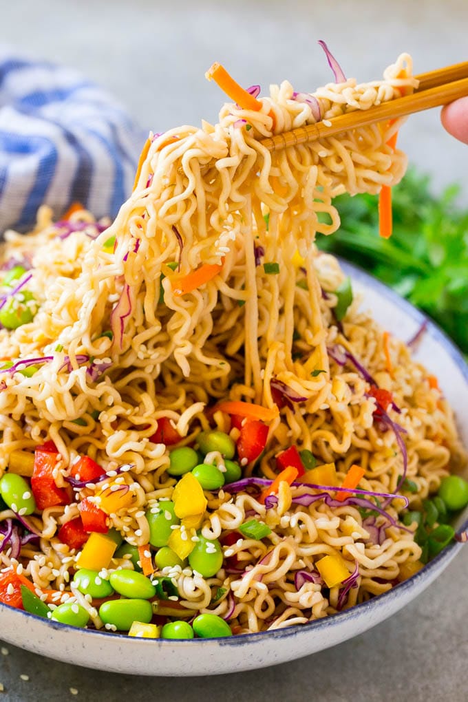 Asian Noodle Salad Recipe | Ramen Noodle Salad | Asian Salad #salad #noodles #edamame #vegetarian #ezlod #lunch Chopsticks picking up noodles in a vegetable salad.