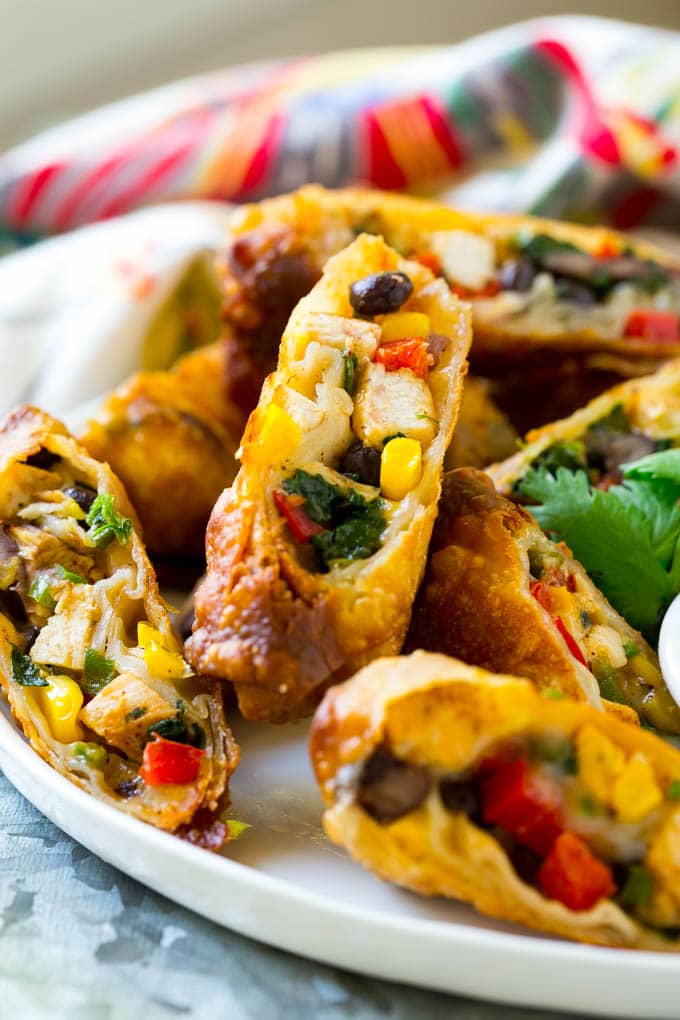 Southwestern Egg Rolls Recipe | Easy Egg Roll Recipe | Mexican Appetizer | Egg Roll Recipe | Southwest Egg Rolls #eggrolls #appetizer #chicken #snack #ezlod Chicken egg rolls with colorful vegetables, cut and served with avocado ranch sauce.