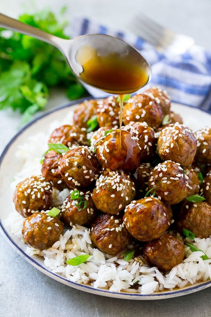 Teriyaki Meatballs Recipe | Asian Meatballs Recipe | Easy Meatball Recipe | Appetizer Meatballs #meatballs #teriyaki #beef #rice #dinner #ezlod Teriyaki sauce spooned over a pile of meatballs on a bed of rice.