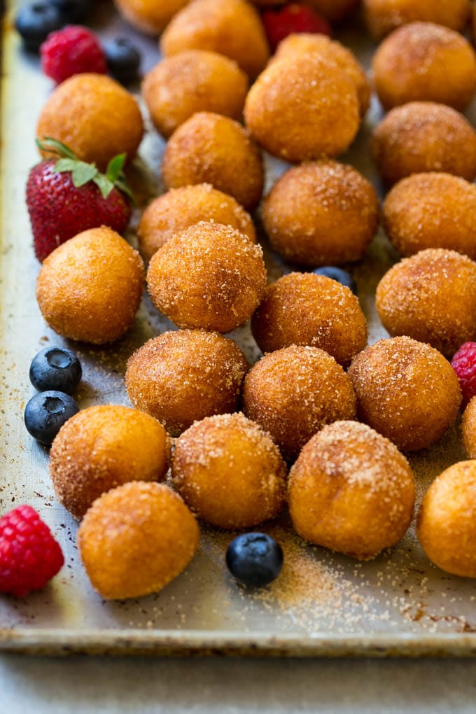 Donut Bread Pudding Recipe | Easy Bread Pudding | Cinnamon Donuts | Make Ahead Breakfast Recipe #breadpudding #donuts #donutholes #breakfast #ezlod Cinnamon sugar donut holes on a tray surrounded by berries