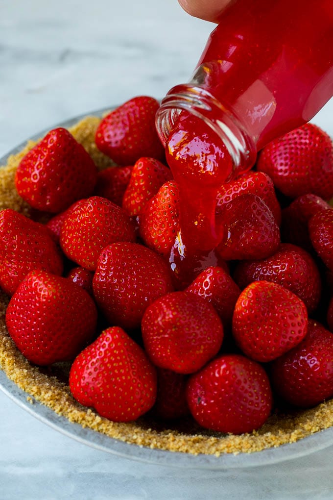 No Bake Strawberry Pie Recipe | Fresh Strawberry Pie | Strawberry Pie Recipe | No Bake Pie Recipe #strawberry #strawberrypie #nobake #nobakepie #dessert #ezlod Glaze being poured over a strawberry pie.