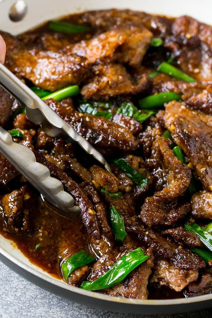 Mongolian Beef Recipe | Asian Beef Recipe | Chinese Beef | Beef Stir Fry #Chinese #Mongolian #Asian #mongolianbeef #beef #ezlod #dinner A pan of Mongolian beef with tongs in it.