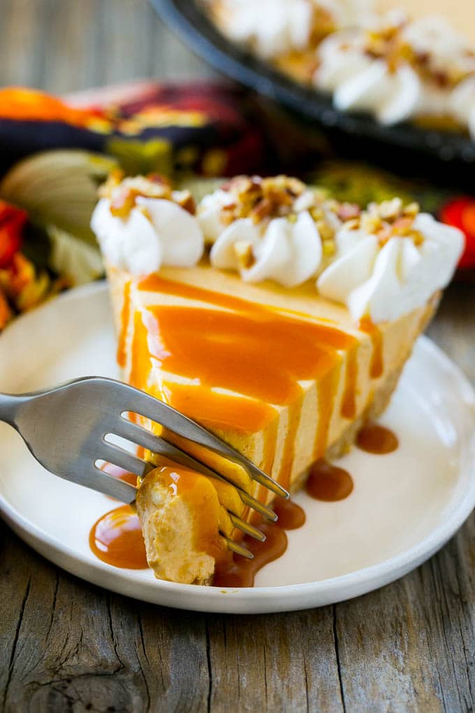 No Bake Pumpkin Cheesecake Recipe | Pumpkin Cheesecake | No Bake Cheesecake | Thanksgiving Dessert | Pumpkin Dessert #nobake #cheesecake #pumpkin #pumpkinpie #pumpkincheesecake #nobakecheesecake #dessert #ezlod A fork cutting into a slice of no bake pumpkin cheesecake.