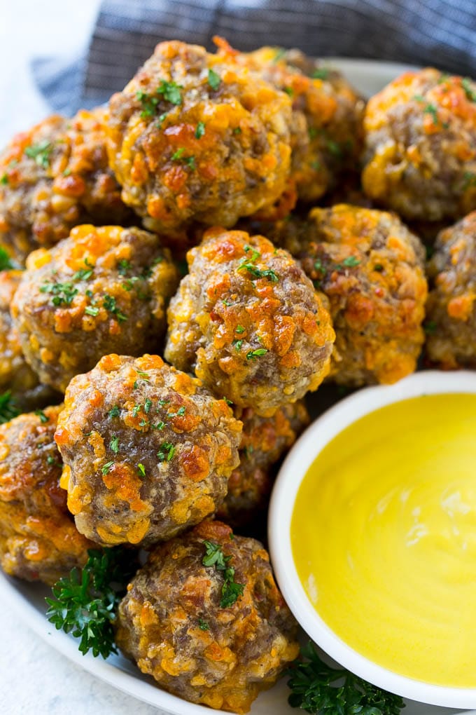 Sausage Cheese Balls Recipe | Sausage Balls Recipe | Bisquick Sausage Balls #sausage #sausageballs #balls #appetizer #cheeseballs #ezlod A platter of sausage cheese balls with honey mustard sauce for dipping.