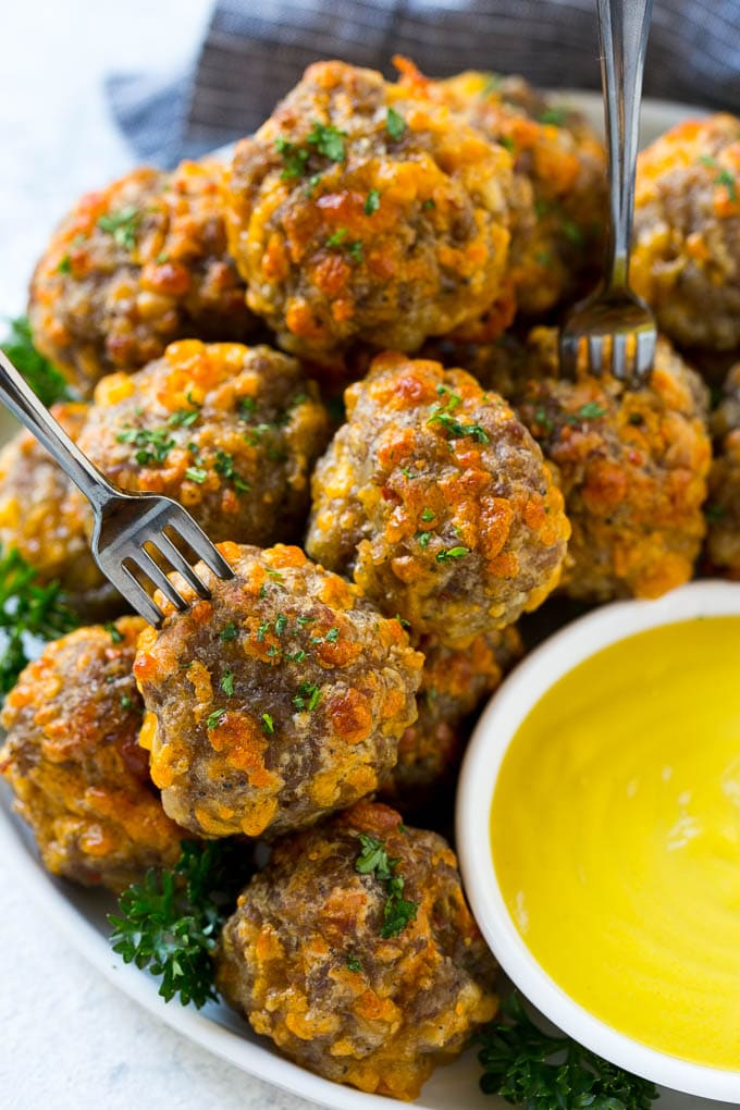 Sausage Cheese Balls Recipe | Sausage Balls Recipe | Bisquick Sausage Balls #sausage #sausageballs #balls #appetizer #cheeseballs #ezlod A plate of meatballs with cocktail forks.