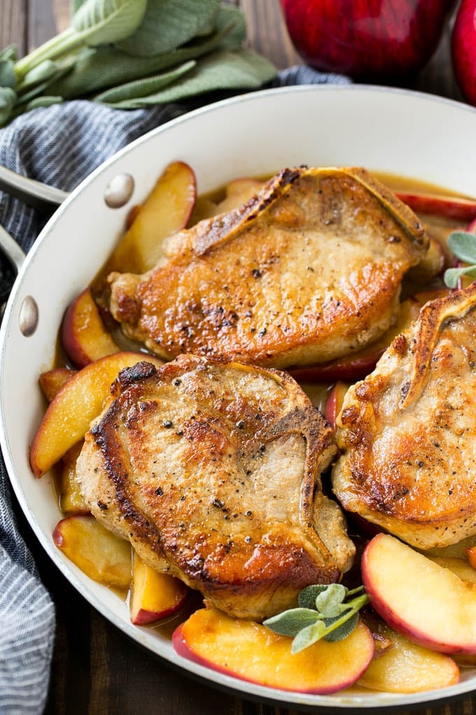 Apple Pork Chops Recipe | Pork Chops with Apples | Cider Pork Chops | Bone In Pork Chops Recipe #pork #porkchops #fall #apple #dinner #ezlod A pan of apple pork chops garnished with fresh sage.