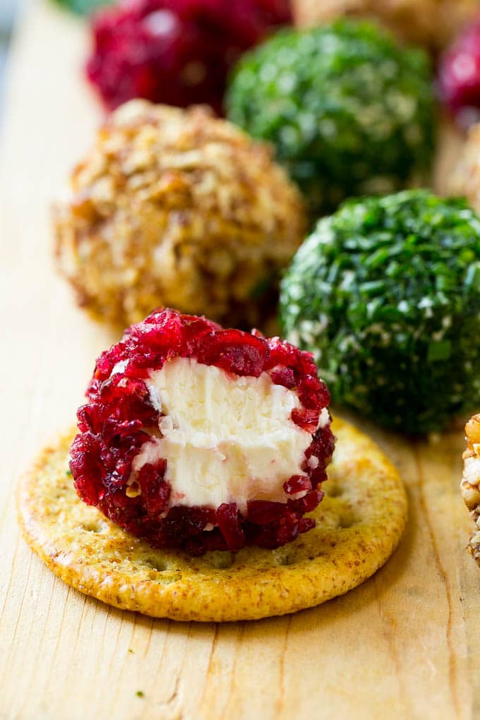 Cheese Ball Bites Recipe | Holiday Cheese Ball Recipe | Pecan Cheese Ball | Cranberry Cheese Ball | Mini Cheese Balls #cheeseball #cheese #appetizer #ezlod A cranberry crusted ball of cheese on a cracker.