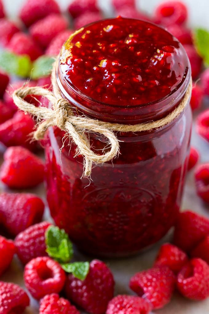 Raspberry Sauce Recipe | Homemade Raspberry Sauce | Raspberry Recipe #raspberries #dessert #ezlod A jar of homemade raspberry sauce surrounded by fresh raspberries.