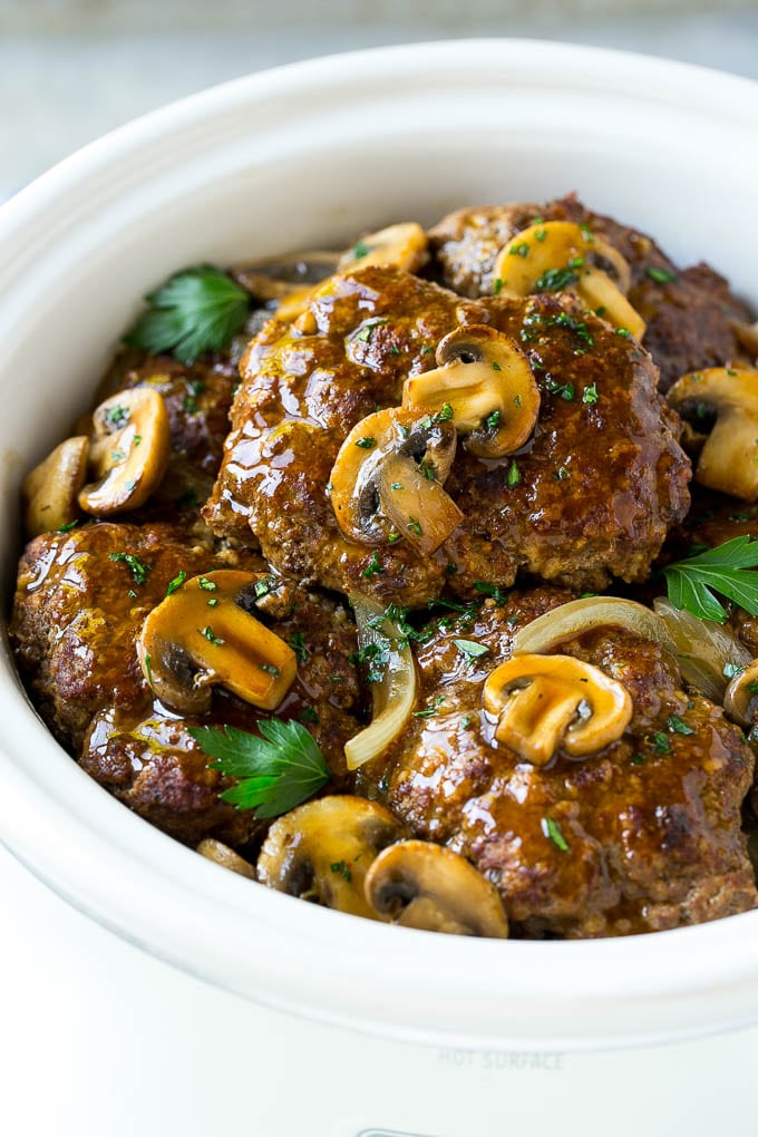 Slow Cooker Salisbury Steak Recipe | Homemade Salisbury Steak | Salisbury Steak from Scratch #steak #beef #salisbury #salisburysteak #slowcooker #crockpot #dinner #ezlod A crock pot with hamburger patties, cooked mushrooms and gravy.