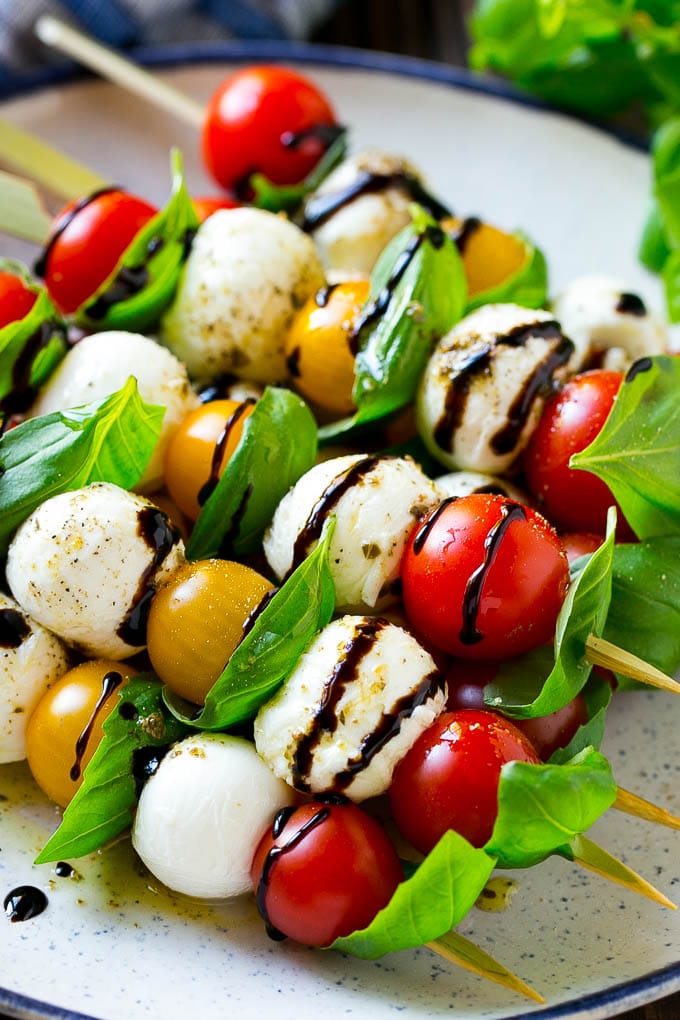 Caprese Skewers | Caprese Kabobs | Caprese Appetizer #tomato #mozzarella #basil #caprese #appetizer #ezlod A plate of caprese skewers with mozzarella, tomatoes and basil.
