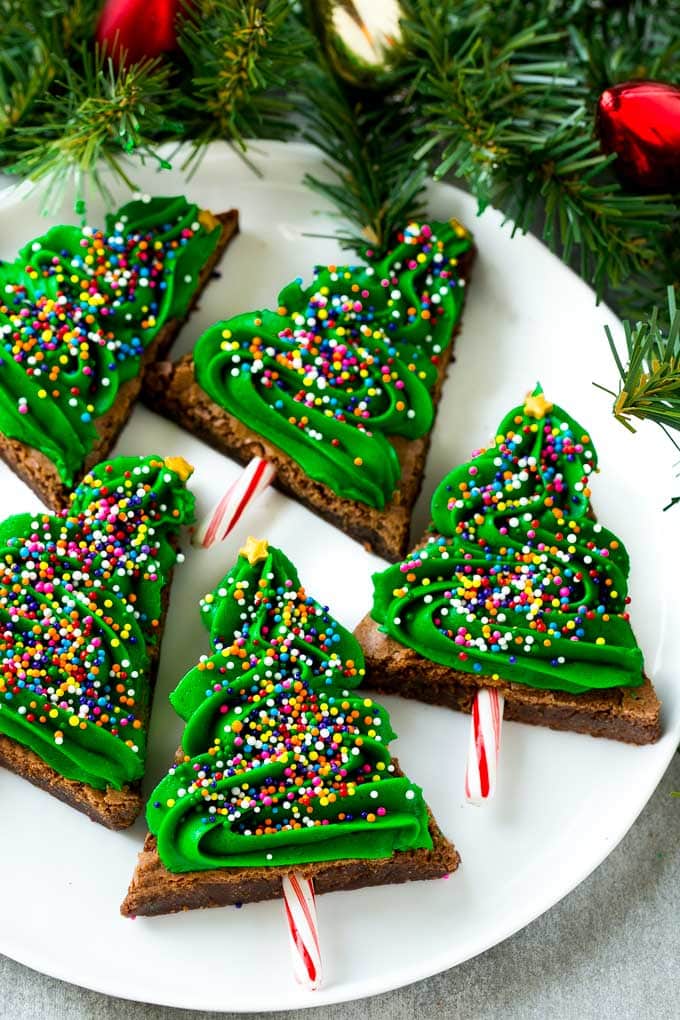 title="Christmas Tree Brownies | Christmas Brownies | Holiday Brownies | Christmas Tree Dessert #brownies #dessert #christmas #holiday #dessert #ezlod" Christmas Brownies topped with frosting and rainbow sprinkles on a plate.