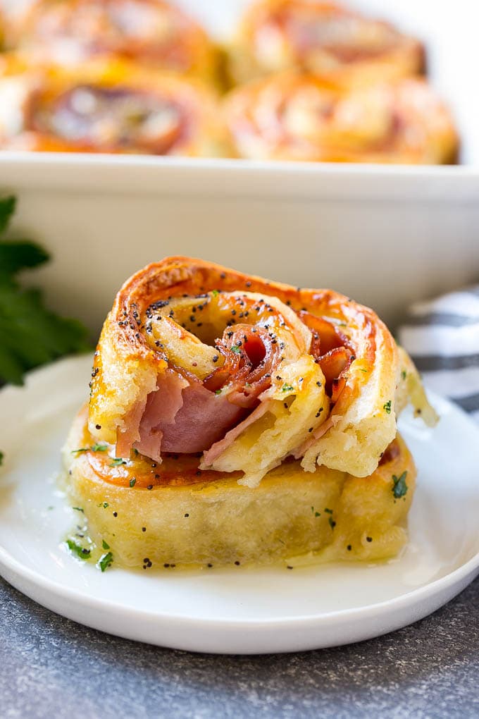 Ham and Cheese Pinwheels Recipe | Ham and Cheese Roll Ups | Ham and Cheese Rolls | Ham and Cheese Bread Rolls #ham #cheese #appetizer #pinwheels #ezlod Ham and cheese pinwheels stacked on a serving plate.